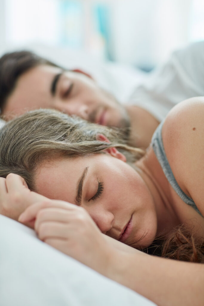 Couple sleeping peacefully together in bed