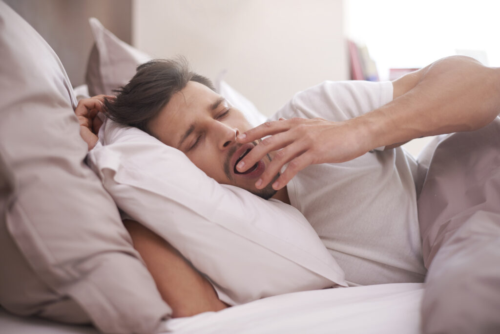 man-with-dark-hair-sleeping-in-bed